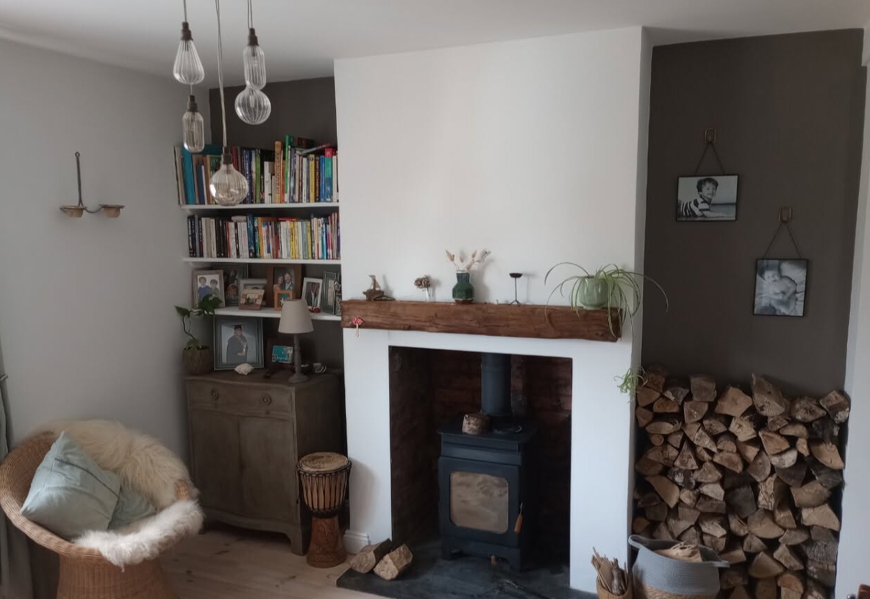 Finished living room with a white chimney breast and a log burner