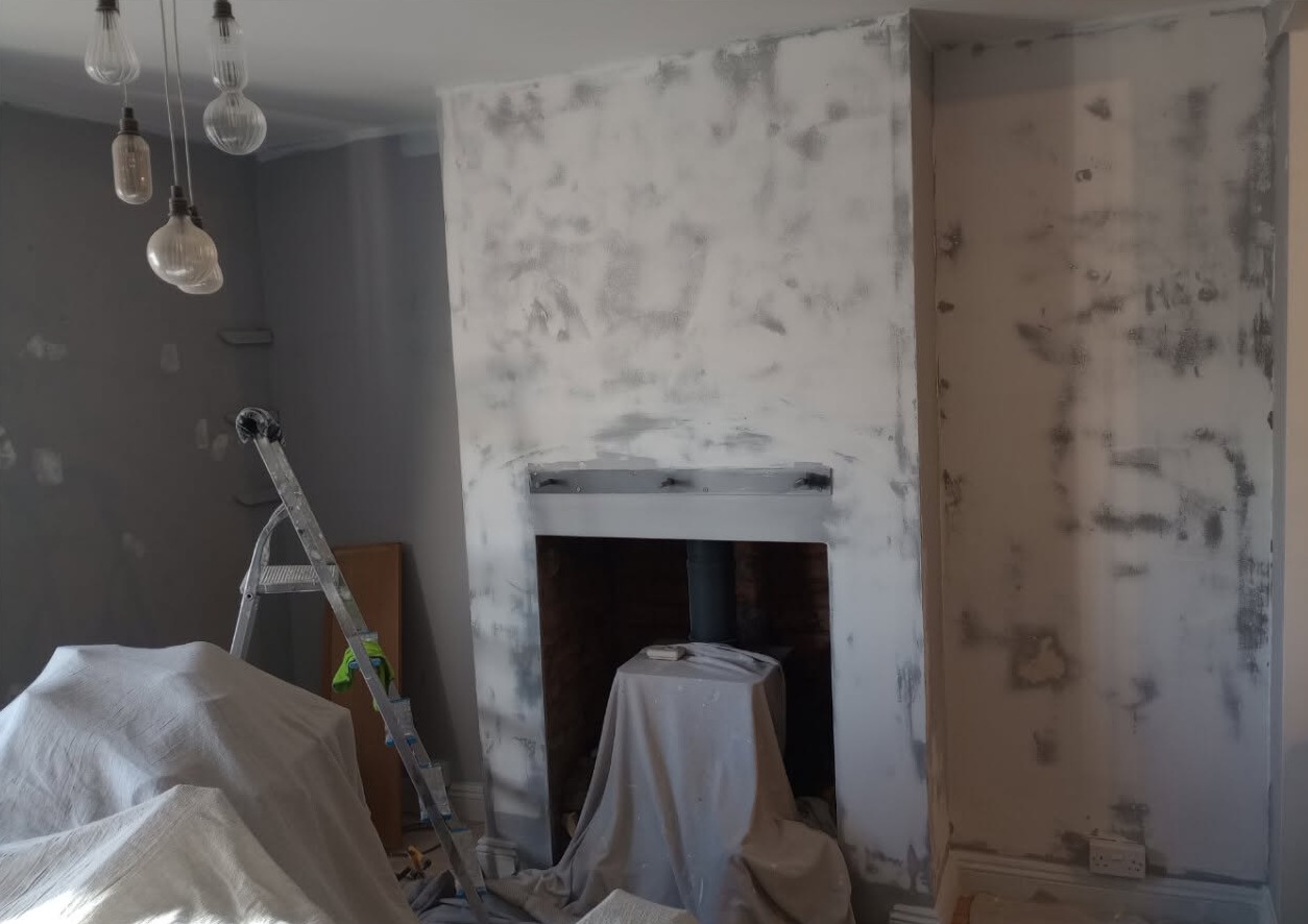 Chimney breast filled and sanded, furniture under dust sheets