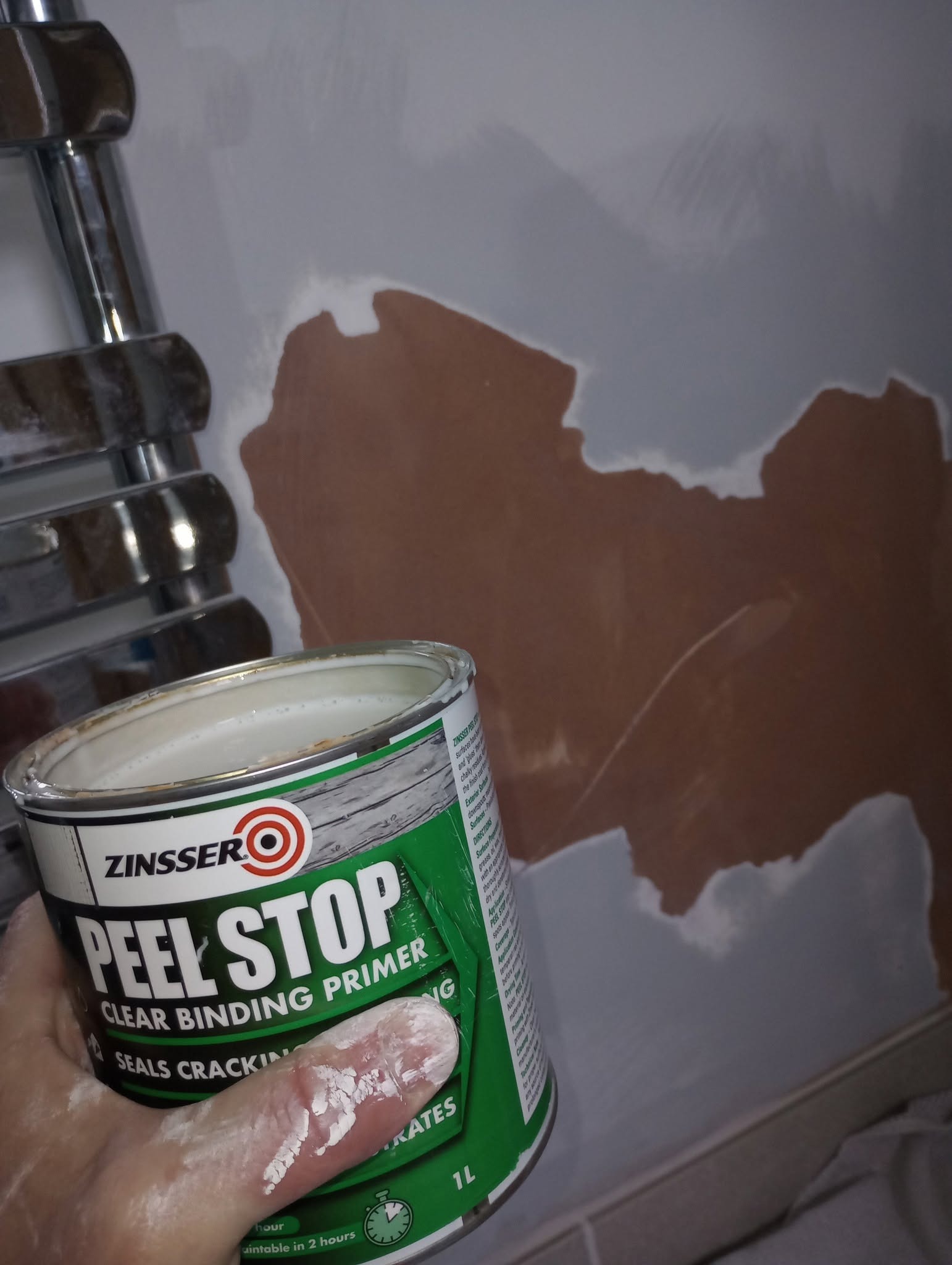 Flaking wall being treated with a primer before painting