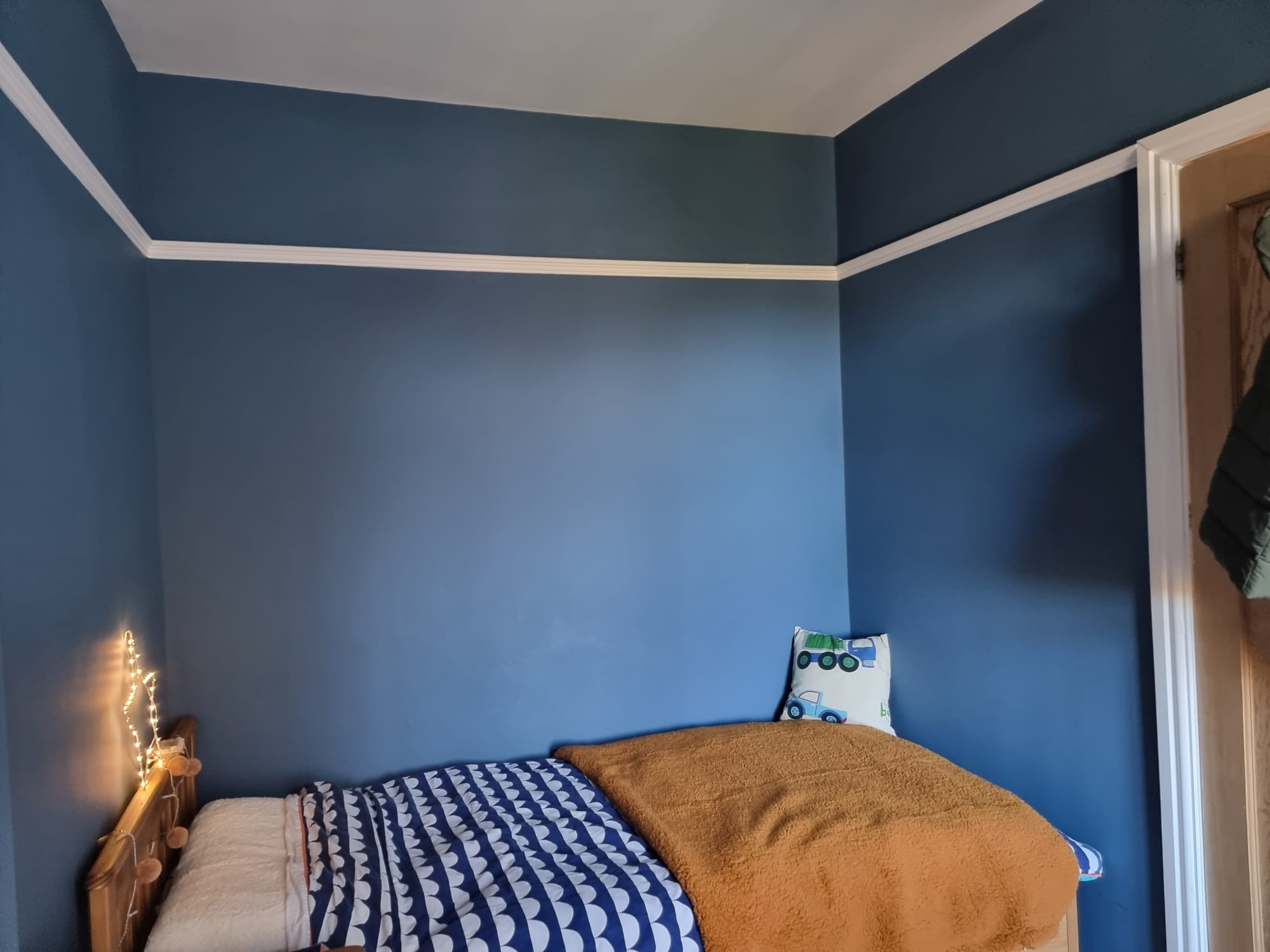 Deep blue child's bedroom with a white picture rail